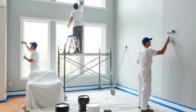 Professional interior house painters working in Worcester, MA living room with expert wall painting craftsmanship
